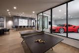 The "19th Hole" basement entertainment zone features a glass-enclosed collector-car showroom, distinctive wet bar and plenty of room for enjoying leisure activities. 

European oak flooring by Dachateau and lighting from Circa Lighting warm up the space.
	
The Village at Seven Desert Mountain—Scottsdale
Architecture: Drewett Works
Builder: Cullum Homes
Interiors: Ownby Design
Landscape: Greey | Pickett
Photographer: Dino Tonn

https://www.drewettworks.com/the-model-home-at-village-at-seven-desert-mountain/
