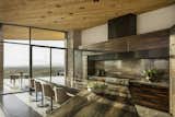 Sun streams across the kitchen's Galapagos Quartzite countertops and macassar ebony cabinetry highlighting the beautiful warm tones which are echoed in the cedar ceiling. Material transitions are seamless from indoors to out making the space, when glass doors are opened, visually connected.

Estancia Club
Builder: Peak Ventures
Interiors: Ownby Design
Photography: Jeff Zaruba