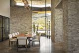 Imported from Thailand, the Acacia wood live-edge dining table adds texture and warmth to the split-faced silver travertine dining room. Clerestory windows flood the space with light, and the custom wine room adds beautiful and accessible storage.

Estancia Club
Builder: Peak Ventures
Interior Designer: Ownby Design
Landscape: High Desert Designs
Photography: Jeff Zaruba