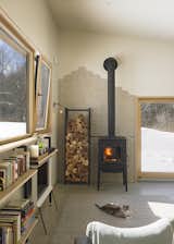 This passive house home in Little Flats, New York designed by in.site:architecture only uses a cord of firewood during its first winter, and its stacked firewood cache is stored next to the fireplace on a tall, slim piece of furniture.