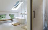  In the master bathroom, a soaking tub sits beneath a sloped roof with a skylight.