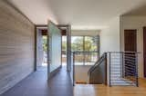 Interior view of the pivot entry door, hot rolled steel panel at the staircase and interior shou sugi ban siding.