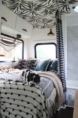 One of their dogs, Cudi, blends in with textiles that overflow on the bed in their RV.