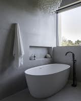 Primary bath freestanding tub with niche and porcelain tiled walls.