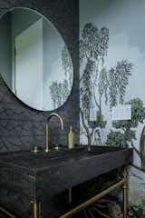 Powder room with wall mural, stone console sink, Ann Sacks glass tile, and brass fixtures. 