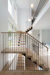 Floating multi-level steel stairs with oak treads and top rail.
