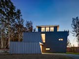 Beyond the functional requirements, the architects’ concept for the roof form took on a dominant role in the building design: it folds up, around and down to shelter the house to the north and open up to views to the south. The standing seam metal roof allow for easy clipping of the solar panels.    Photos