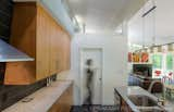 Kitchen, Wood Cabinet, Ceramic Tile Backsplashe, Granite Counter, Concrete Floor, Ceiling Lighting, Dishwasher, and Undermount Sink The battered north wall adds interest to the simple kitchen design.  Photo 10 of 16 in Dogtrot at Stony Point by hays+ewing design studio