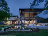 The great room appears to hover over the pool.  Fully glazed at night it becomes a lantern as seen from the shore.
