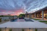Outdoor, Back Yard, Shrubs, Grass, Hardscapes, Trees, Flowers, Walkways, Swimming Pools, Tubs, Shower, Standard Construction Pools, Tubs, Shower, Large Patio, Porch, Deck, Large Pools, Tubs, Shower, Pavers Patio, Porch, Deck, Concrete Patio, Porch, Deck, Metal Fences, Wall, and Landscape Lighting Fanfol Pool and Negative Edge spa with Swim Up Seating/Bar Area  Photo 16 of 29 in Desert Dryscapes by Belyaev