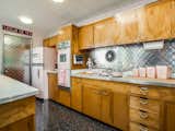 Kitchen, Metal Backsplashe, Wood Cabinet, Ceiling Lighting, Wood Counter, and Cooktops  Photo 13 of 36 in Candy-Colored Mid-Century Modern Throwback by Zillow