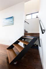 The architects, owners of a New Orleans design build firm, fabricated a pivoting stair to allow access to under stair storage. Painting by Tiffany Lin.