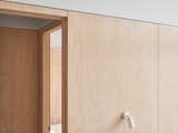 White walls balanced with plywood panelling adds a modern and timeless look throughout the home, accentuating the coastal lifestyle of the home's location.