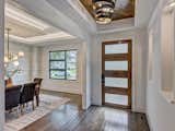 The foyer of the home with wood inlaid tray ceiling and art niches. 