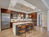 The kitchen with waterfall countertops and floating dine-in bar