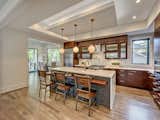 Kitchen with custom cabinets, LED uplighting, and herringbone glass backsplash