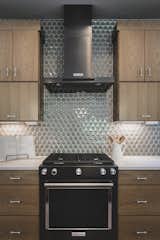 Black stainless appliances with 3D Hex backsplash and top hinge cabinetry