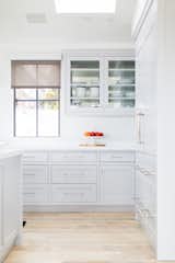 Kitchen, White Cabinet, Engineered Quartz Counter, Ceiling Lighting, Light Hardwood Floor, and Refrigerator Soft, gray, flush framed cabinets provide a more traditional, timeless touch to this otherwise modern home.   Photo 5 of 10 in Manhattan Ave Residence by Laney LA