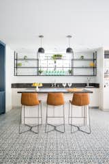 The beach room bar utilizes high windows, due to the sunken retaining walls required at the upper end of the site. Dark stone slabs compliment the coated steel shelving. Raw leather stools provide the accent of color, against the personality of the cement tile floor. 