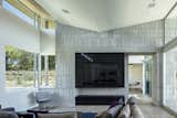 living area focal wall, featuring the ribbon fireplace/TV detail, limestone veneer and sloped ceiling