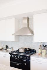 Kitchen, Engineered Quartz Counter, White Cabinet, Stone Slab Backsplashe, Range, and Range Hood  Photo 5 of 11 in Classically Modern by Big Sky Design