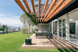 Outdoor, Back Yard, Trees, Concrete Fences, Wall, Gardens, Wood Patio, Porch, Deck, Hanging Lighting, and Grass  Photo 6 of 12 in VISORES HOUSES by TEC Taller EC