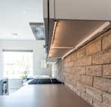 Kitchen, Engineered Quartz, Porcelain Tile, White, Brick, Recessed, Range Hood, and Range LED Lighting and GFI electrical strips are hidden underneath cabinets for a clean look.  Kitchen Range Hood White Brick Photos from Vegas Luxe