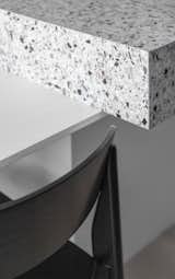 All color accents are united by the porcelain stoneware tiles used on the kitchen island: against the light background, there are splashes of black, gray, and terracotta.