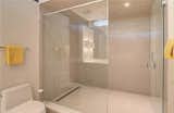 One Piece Toilet, Ceiling Lighting, Porcelain Tile Floor, Full Shower, and Porcelain Tile Wall Main bathroom shower  Photo 18 of 30 in Henderson House by UrbanLab