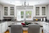 Kitchen, Marble Counter, White Cabinet, Wall Oven, Drop In Sink, Medium Hardwood Floor, and Ceiling Lighting  Photo 2 of 7 in Reimagined 1908 Colonial Revival in Pasadena by Luxe Angeles