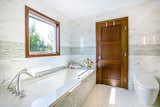 Bath Room, Porcelain Tile Floor, Soaking Tub, Engineered Quartz Counter, Undermount Tub, Ceiling Lighting, Mosaic Tile Wall, One Piece Toilet, and Porcelain Tile Wall  Photo 8 of 8 in The Hillside Second Story by SATO Architects