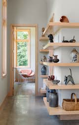 Cantilevered maple shelving at the central stair shows off an eclectic art collection.