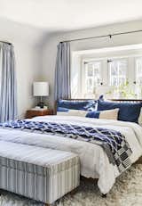 Emily Henderson uses Brooklinen’s classic duvet cover and matching sheets in her own master bedroom. A Schoolhouse Electric blanket, shams from Parachute, and a Target footstool covered in a custom fabric complete the look.