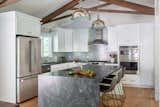 Kitchen, Stone Counter, Ceramic Tile Backsplashe, Medium Hardwood Floor, Undermount Sink, Pendant Lighting, and White Cabinet Renovation of the Kitchen with a one sided waterfall island stone countertop  Photo 6 of 15 in Conservative Contemporary by VAKOTA  architecture