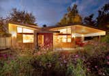 The front elevation of the Courtyard House showing the swooping butterfly roof and accent color.
