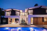 Out back, a rectangular swimming pool with ample space for lounging complements and highlights the home’s angular exterior.