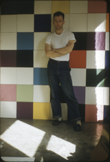 Contemporary artist Ellsworth Kelly stands in front of colorful cubes.