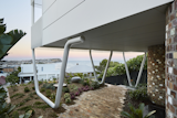 Outdoor, Gardens, Pavers Patio, Porch, Deck, Garden, Front Yard, and Walkways The top floor of the home is propped on three large steel supports that resembles paperclips.  Photo 2 of 9 in A Futuristic Abode in Australia Draws Inspiration From Star Wars
