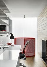 The home office is paneled in wood with perforated steel shelving. &nbsp;