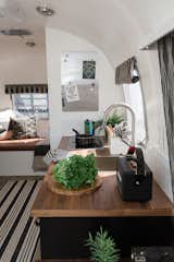 In lieu of purchasing expensive RV blinds, Cole made custom coverings for the trailer’s curved windows with leather straps that snap onto the walls.