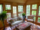 Inside the Birdhouse, walls of windows make for a bright and cheerful sunroom.