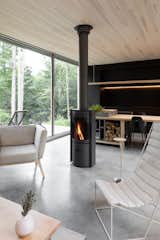 A rotating wood stove in the center of the open-concept living and dining area provides 360-degree access to the fire.