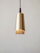 Arthur Umanoff originally designed his brass-and-walnut pendant light for Mobilite.