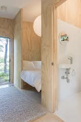 Bath Room, Ceiling Lighting, One Piece Toilet, Wall Mount Sink, Ceramic Tile Wall, and Ceramic Tile Floor A small yet full-sized bath houses a tub, compost toilet and sink.  Photos from The Cofounders of Den, a DIY Cabin Startup, Share a Peek Into Their Catskills Retreat