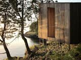 A gray wood exterior allows this sauna on stilts to fade into its forested backdrop.