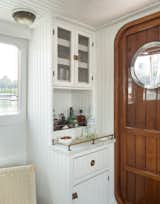 Design elements like white beadboard and brass hardware give the tugboat's interior a classic nautical vibe.