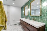 To pay homage to the home’s era, the couple chose a midcentury-inspired Pacific Green Starburst III tile from the Cement Tile Shop to go behind the Moreno Bath MOB rosewood vanity. Hudson Valley Lighting fixtures and CB2 mirrors add some retro bling to the bath.