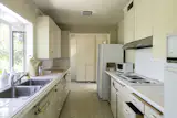 The original galley kitchen was closed off from the living and dining area. “There were lots of little rooms, so we opened that up, and changed up the door situation,” Robert says.  Photo 8 of 22 in Before & After: A Spanish-Style Home in the Hollywood Hills Gets a Sunny California Makeover