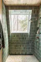 The tile on the shower floor is glazed with a texture to give it the feeling of the outdoors underfoot. “The bathroom has a large skylight that makes it feel like an outdoor shower,” Stagno says. “When you are standing in the shower, you look at the tree canopy.”