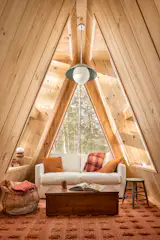 A lofted space doubles as a guest room with a couch that pulls out into a bed. At night guests can see the stars through the skylight while laying in bed.